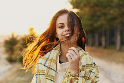 Portrait of smiling young woman standing outdoors