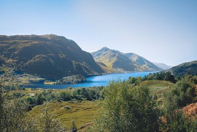 Scenic view of lake and mountains against clear sky