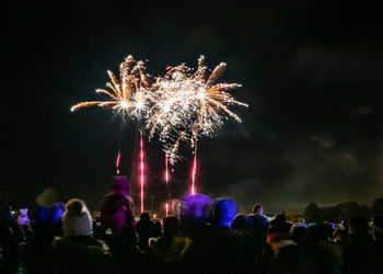 People watching firework display at night