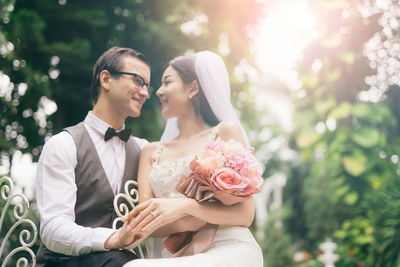 Loving wedding couple sitting at backyard