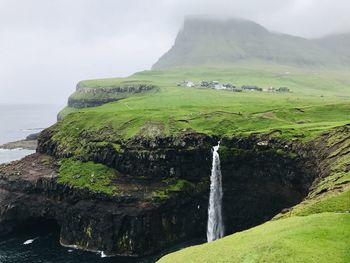 Scenic view of waterfall against sky