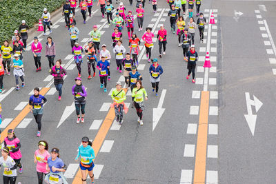 High angle view of people running on road at city