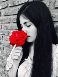 Close-up of beautiful woman holding red flower