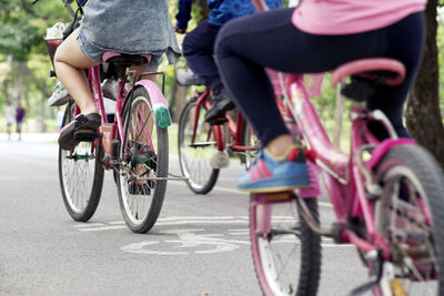 Low section of man riding bicycle on road