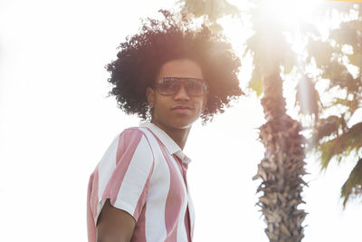 Portrait of young afro latino teenager boy on tropical beach.