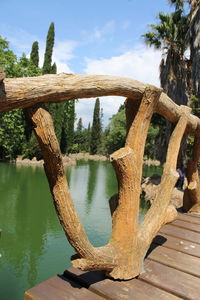 Wooden post by river against sky
