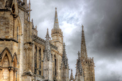 Low angle view of clock tower against cloudy sky