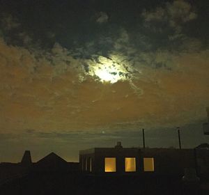 Built structures against sky at sunset