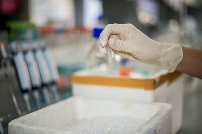 Cropped hand of scientist holding vial at lab