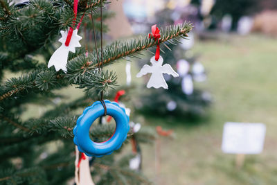 Old todler teething ring toy as a decoration on christmas tree outdoor. environment, reuse, recycle