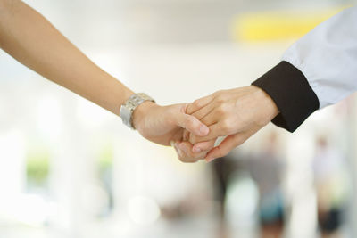 Cropped image of couple holding hands