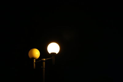 Low angle view of lamp post at night