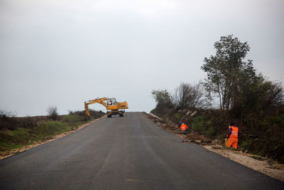 Construction vehicle on road against sky