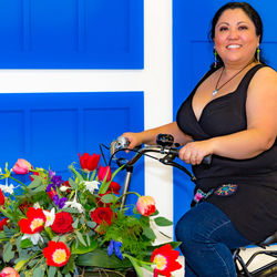 Portrait of a smiling young woman against blue wall