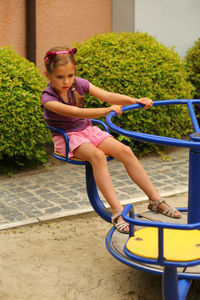 Young woman sitting on slide at playground