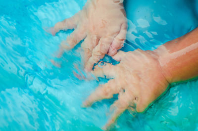 High angle view of woman hands in swimming pool