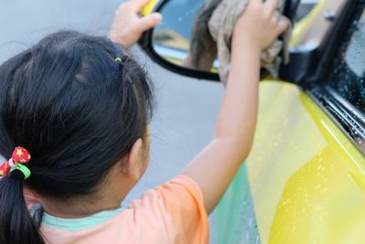 High angle view of girl cleaning car