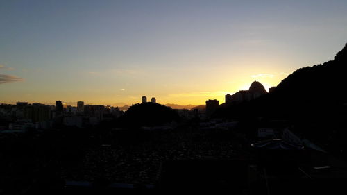 High angle view of silhouette buildings against sky during sunset