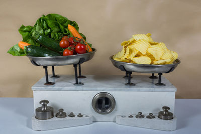 Close-up of potato chips and various vegetables on weight scale