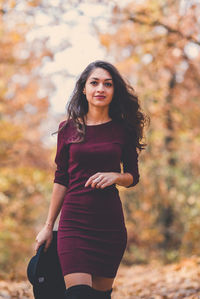 Portrait of beautiful woman standing against tree during autumn