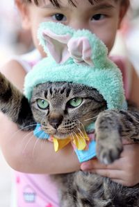 Close-up portrait of girl holding cat