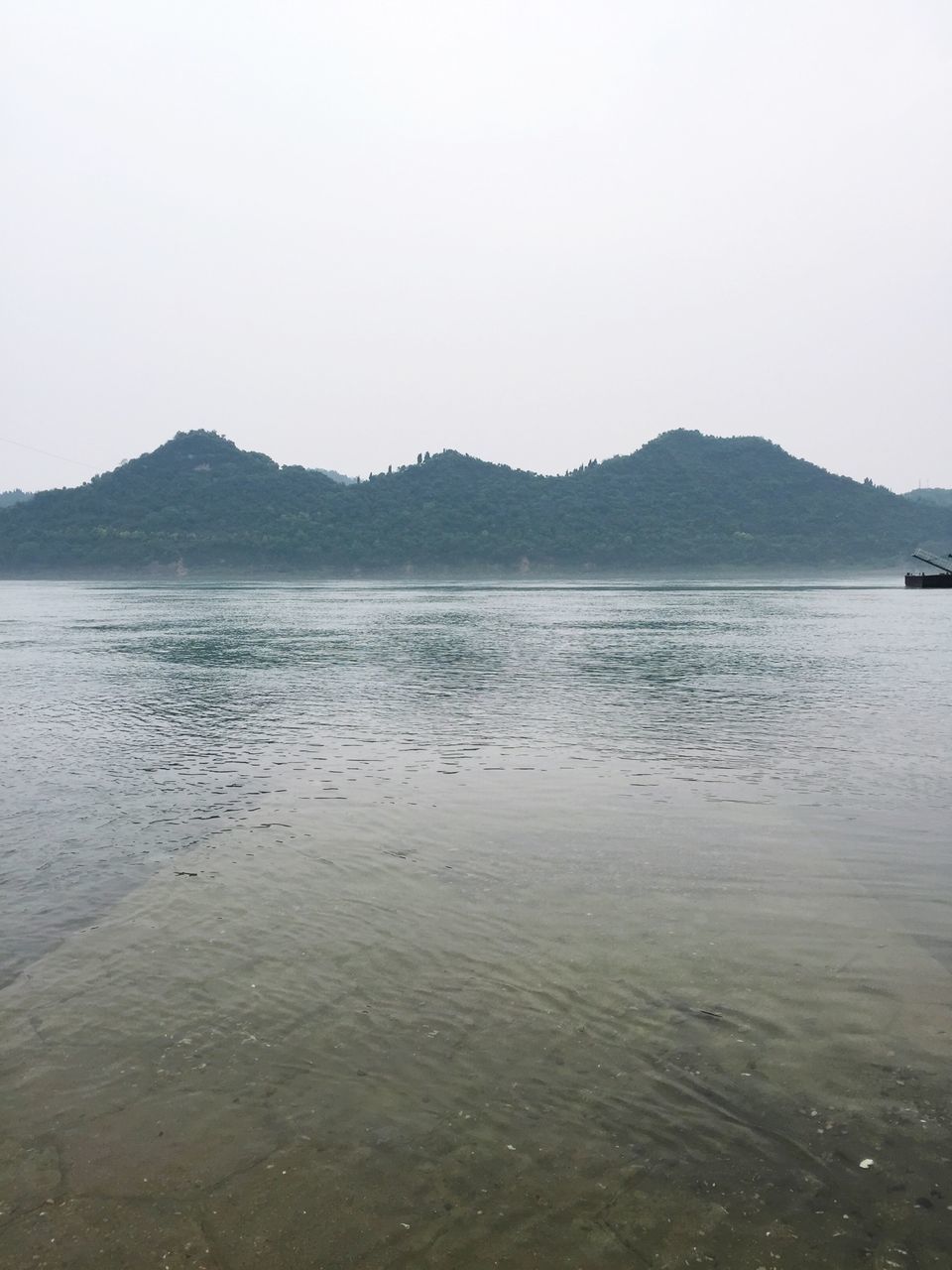 water, mountain, tranquil scene, clear sky, tranquility, scenics, mountain range, beauty in nature, lake, copy space, sea, nature, waterfront, reflection, idyllic, sky, outdoors, rippled, non-urban scene, calm