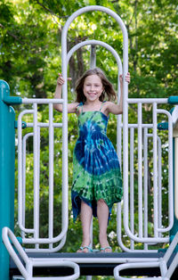 Little girl in green dress posing on the playground