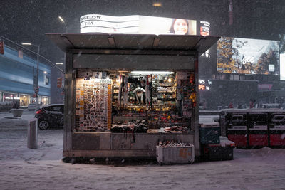 Illuminated street in city during winter