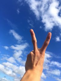 Close up of human hand against blue sky