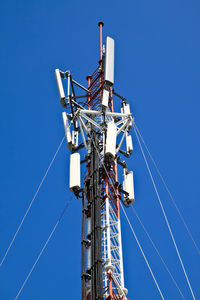 Low angle view of communications tower against blue sky