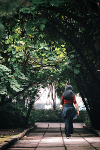 Rear view of woman walking on footpath