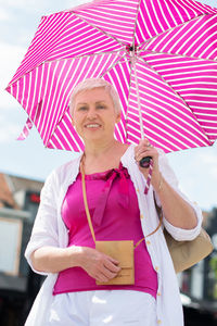 Middle-aged woman with a short haircut with an umbrella protecting from sun