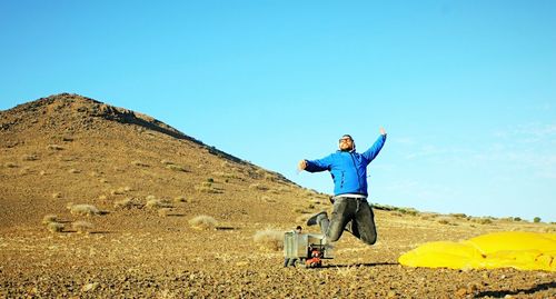 Woman standing on landscape against clear sky