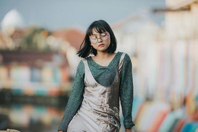 Portrait of beautiful young woman standing outdoors