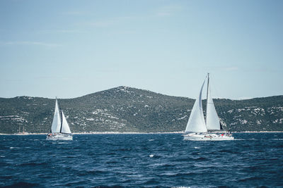 Sailboat sailing on sea against sky