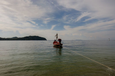 Men on boat in sea against sky