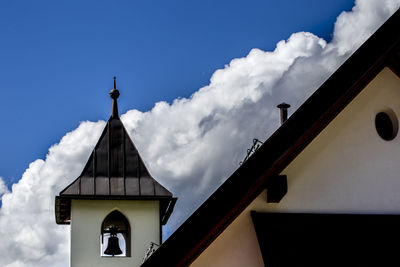 Low angle view of cross on building against sky