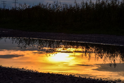 Reflection of trees in lake against sky during sunset