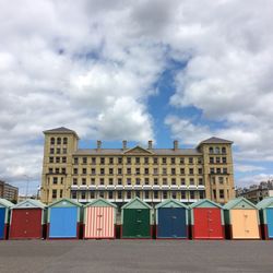 Colorful huts and council building against sky at hove beach