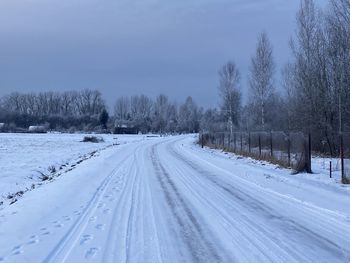 Snow covered landscape against sky