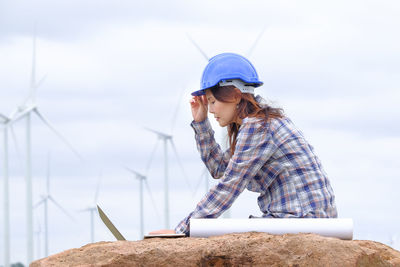 Young woman wearing hat standing against sky