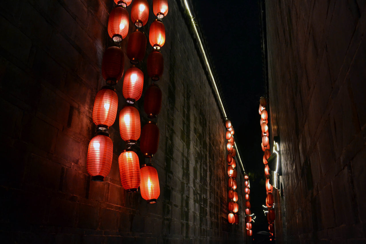 LOW ANGLE VIEW OF ILLUMINATED LANTERNS HANGING FROM CEILING