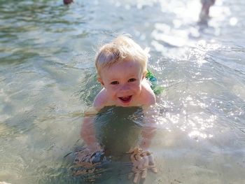 Portrait of cute boy swimming in sea