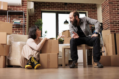 Side view of woman using mobile phone while sitting on sofa at home