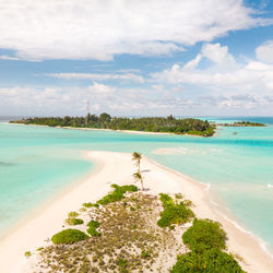 Scenic view of beach against cloudy sky