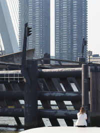 Woman sitting on modern building in city