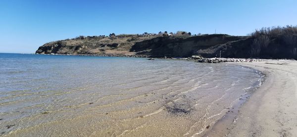 Scenic view of beach against clear blue sky