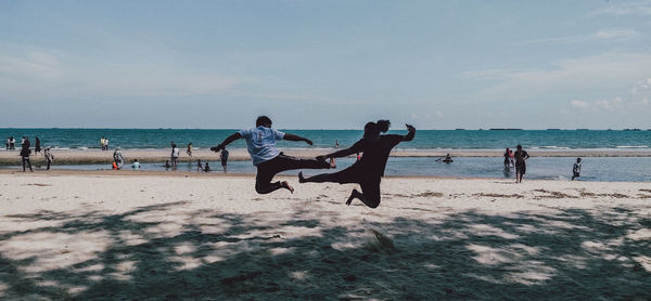 People on beach against sky