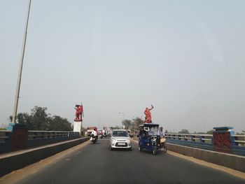 Traffic on road in city against sky