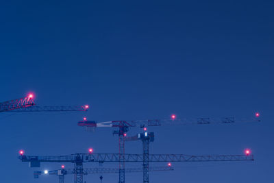 Low angle view of illuminated lights against blue sky at night
